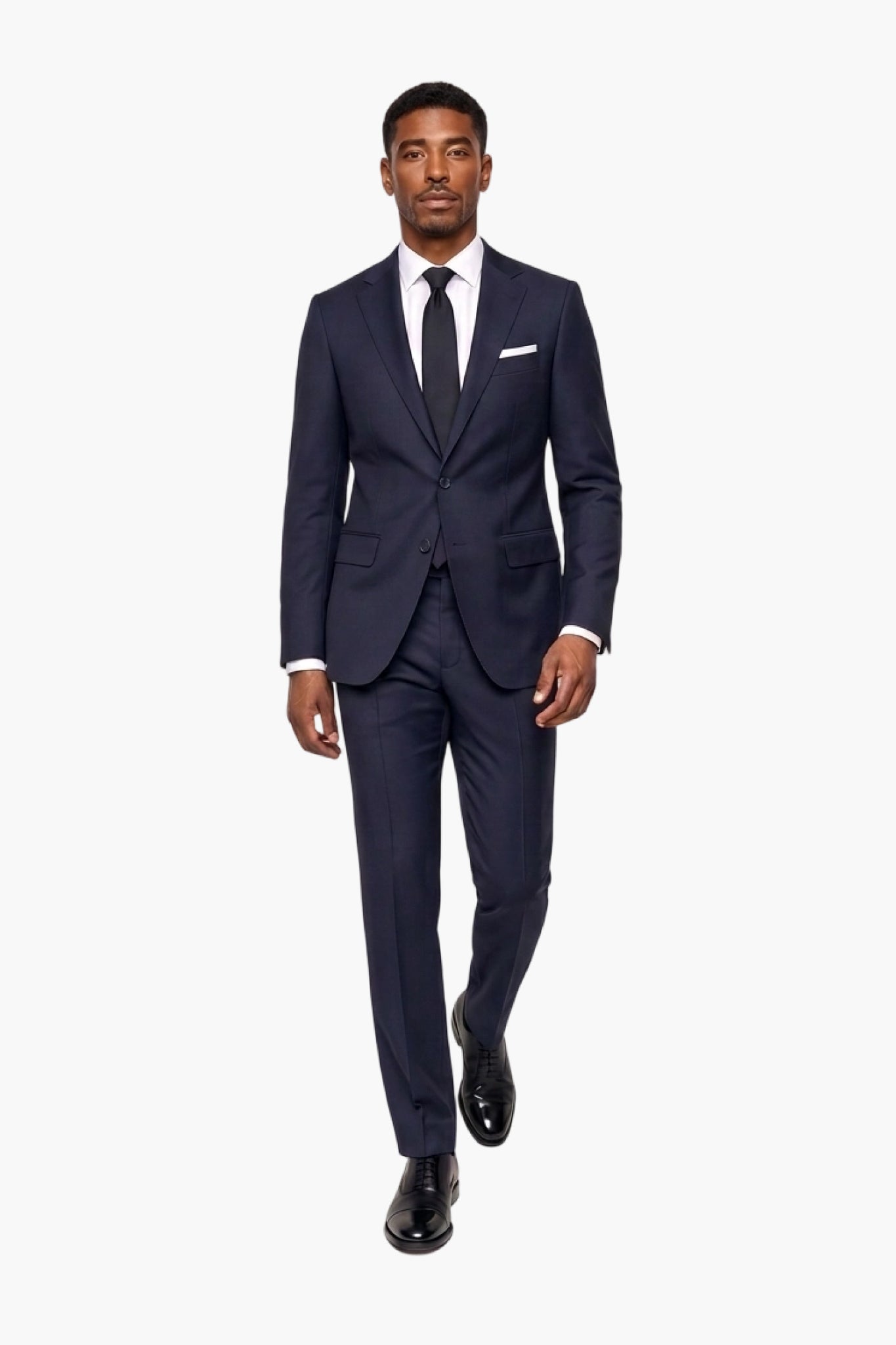 A man modeling a dark navy blue wool two-piece suit with a white dress shirt, a dark tie, and a white pocket square, set against a plain white background.